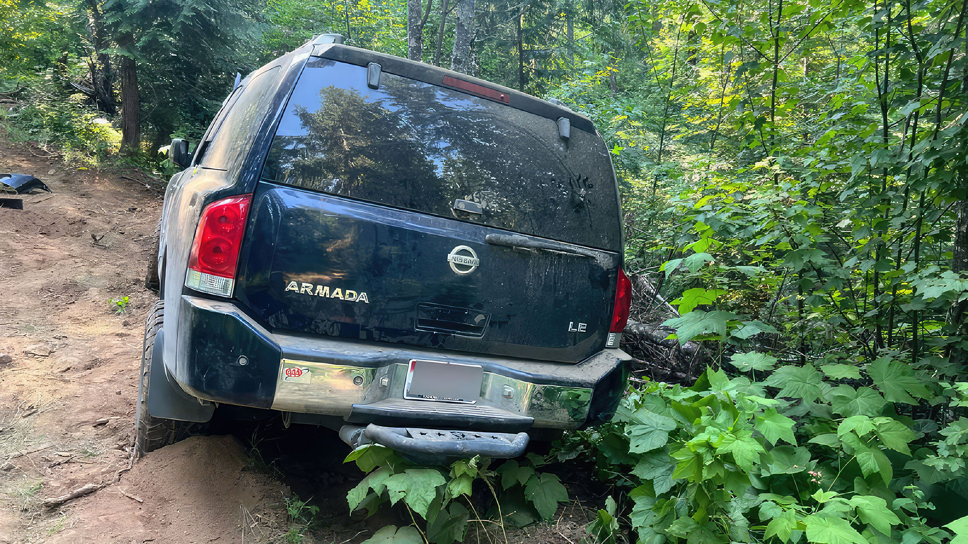 Nissan armada wedged against a tree