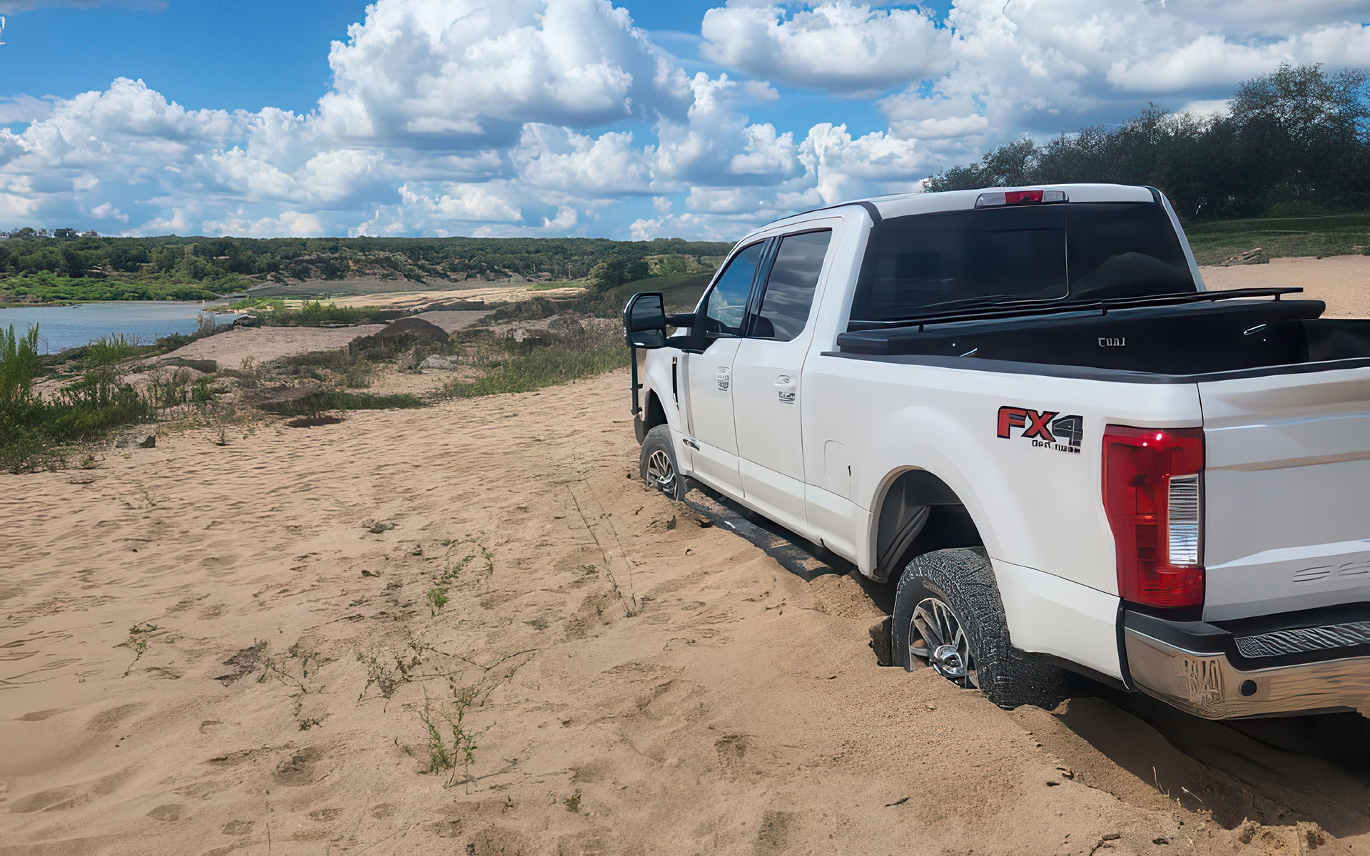 F250 buried to the frame in sand